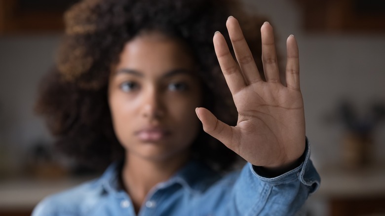 woman holding hand up at camera