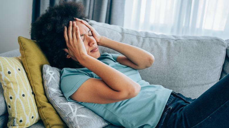 woman anxious holding head on couch