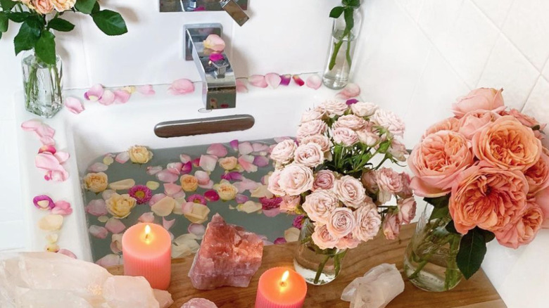 bath with roses, crystals, and candles