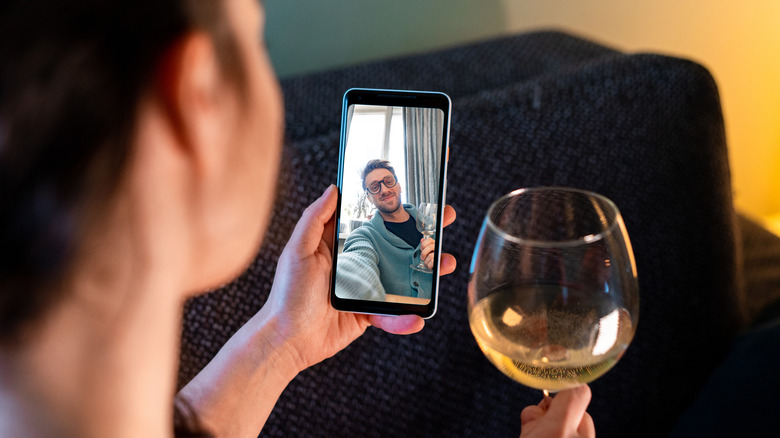 Woman drinks wine during call