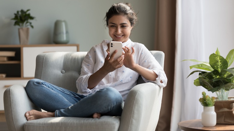 Smiling woman texts using smartphone 