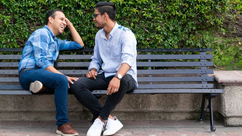 Gay couple talking on bench