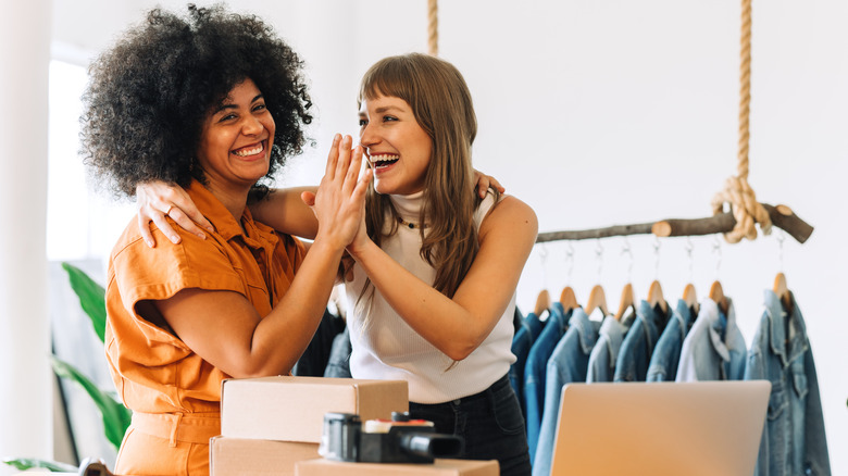 Women high-fiving in store