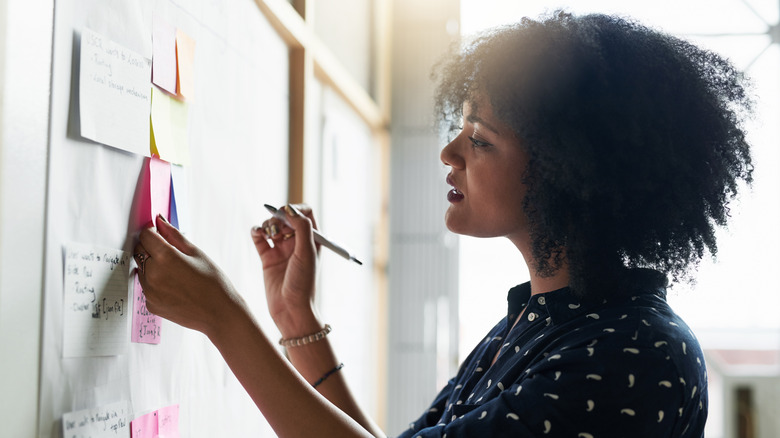 Worker writing on sticky notes