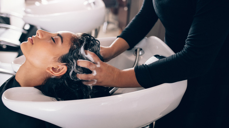 hairdresser washing woman's hair