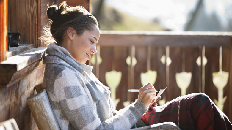 woman writing on notepad 