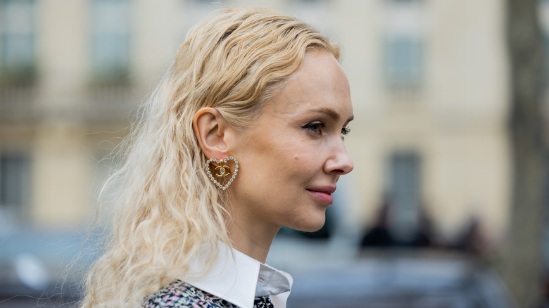 woman wearing Chanel heart-shaped earrings