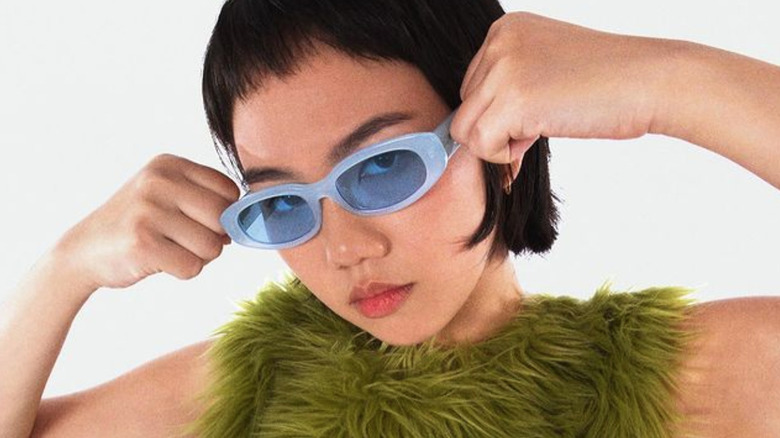 Model wearing blue tinted sunglasses
