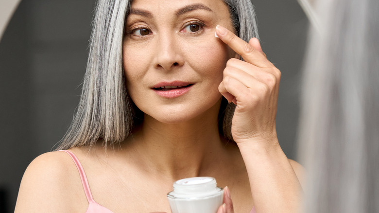 woman applies eye cream