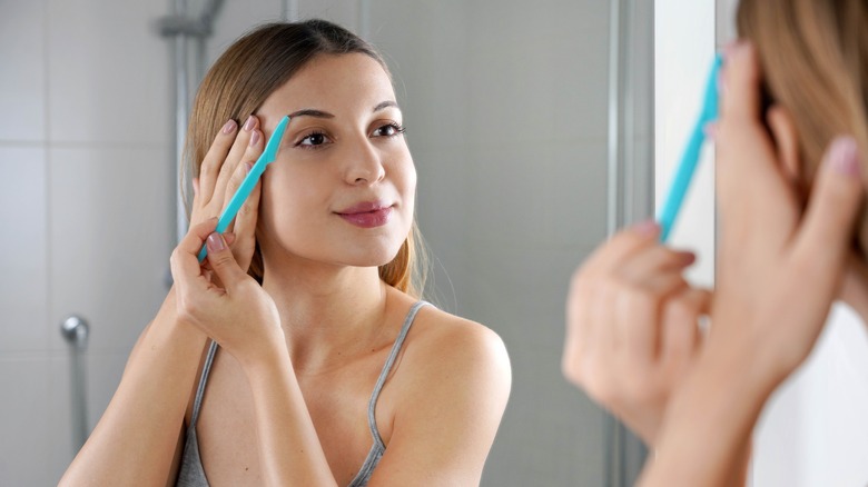 woman using face razor