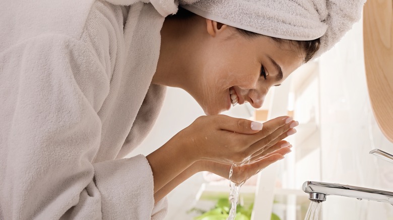 Woman doing skincare in the bathroom washing her face