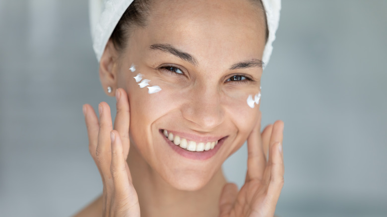 Woman doing skincare with cream on her face