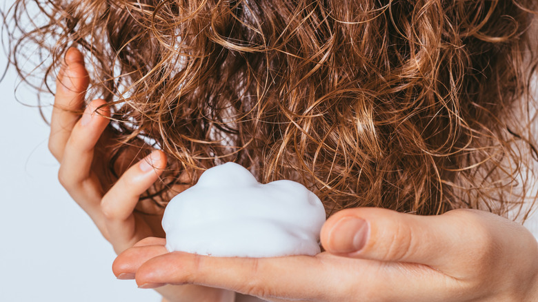 woman applying hair mousse