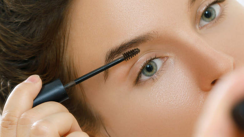 woman applying brow wax 