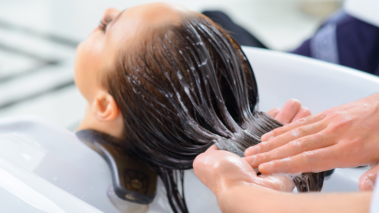 stylist applying mask to woman's hair