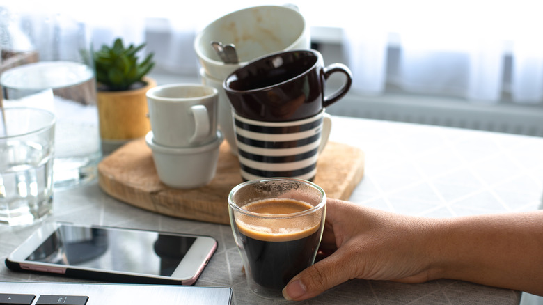 person with multiple coffee cups