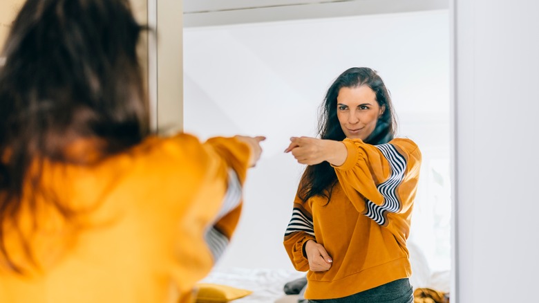 woman confidently pointing to mirror