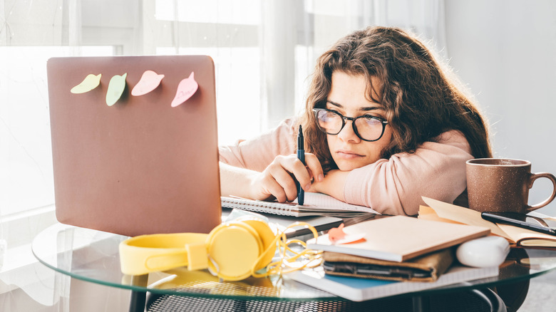 A woman procrastinating at laptop