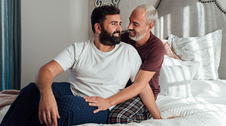 couple holding hands in bed