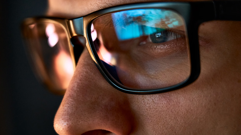 close up of man wearing glasses on the computer