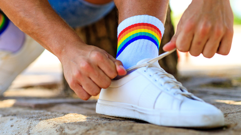 Person tying shoelaces with rainbow socks