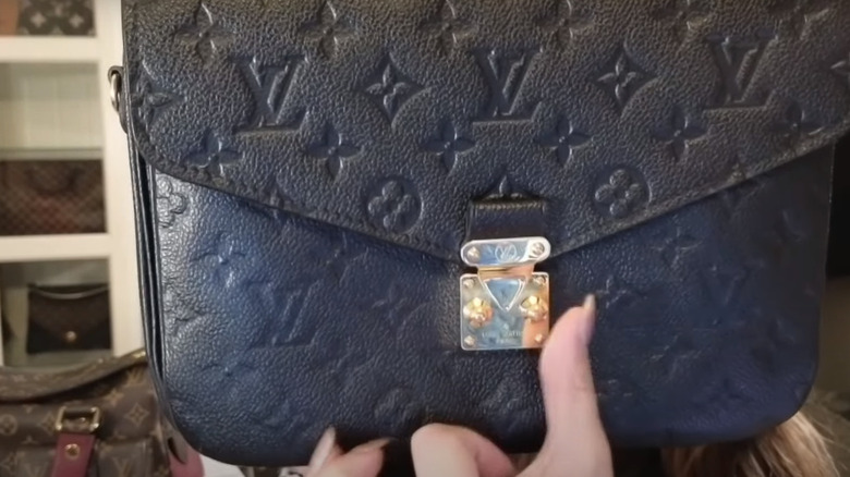 Claudia demonstrating LV bag's S-lock 