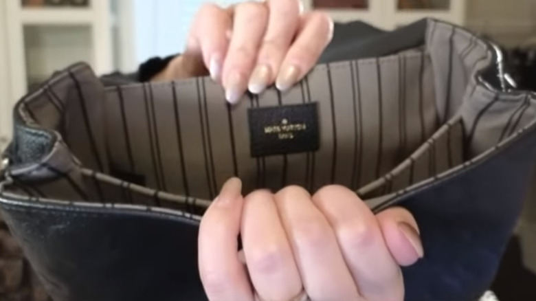 Claudia showing the heat stamp pressed on the inside of LV bag