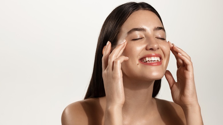 Woman rubbing product into face