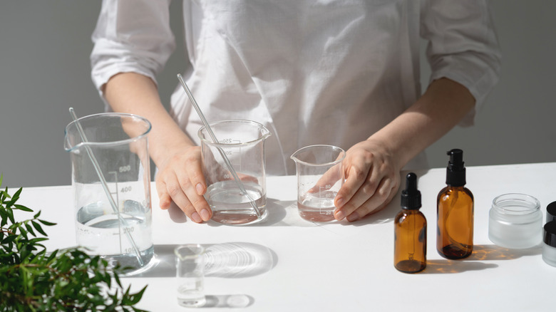 person holding mixing flasks on white table