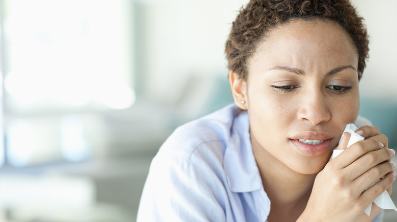 woman crying and holding tissue