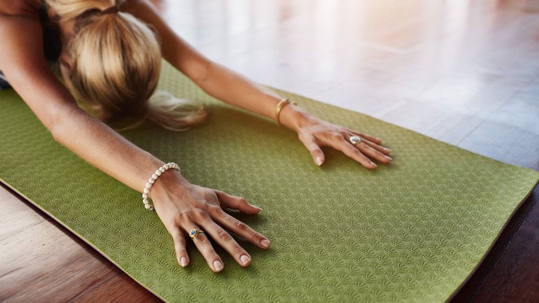 close up of woman on green yoga mat