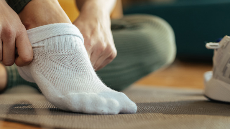 Person putting on athletic socks.