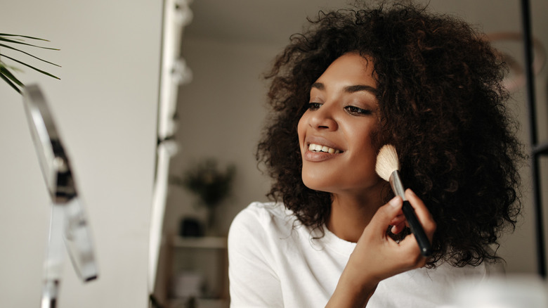 woman applying product with makeup brush