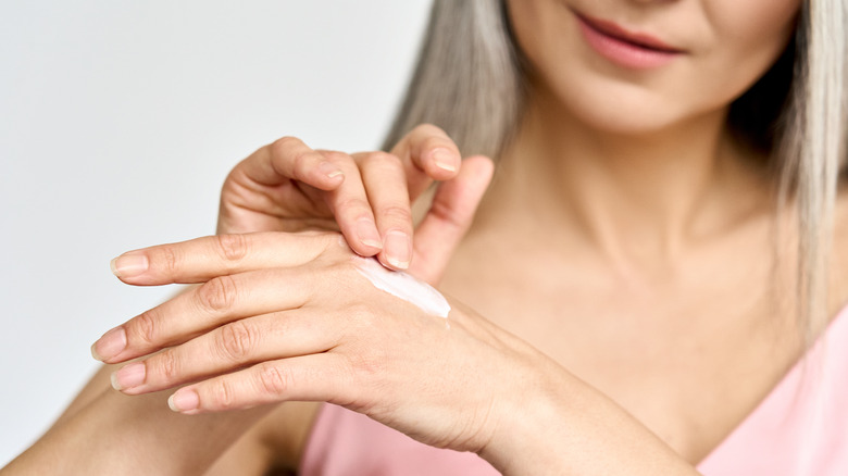 woman applying cream on hand