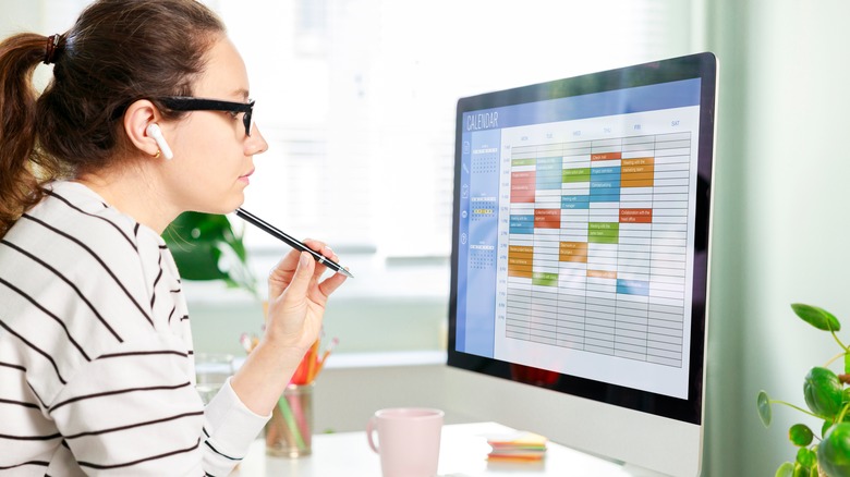woman sitting in front of computer with digital calender