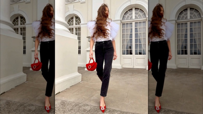 Girl wearing black jeans and red accessories.