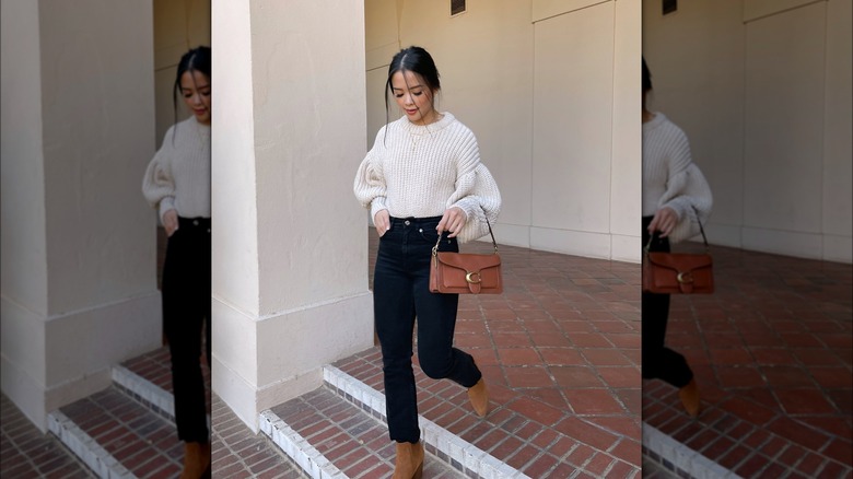 Girl wearing a neutral sweater and boots.
