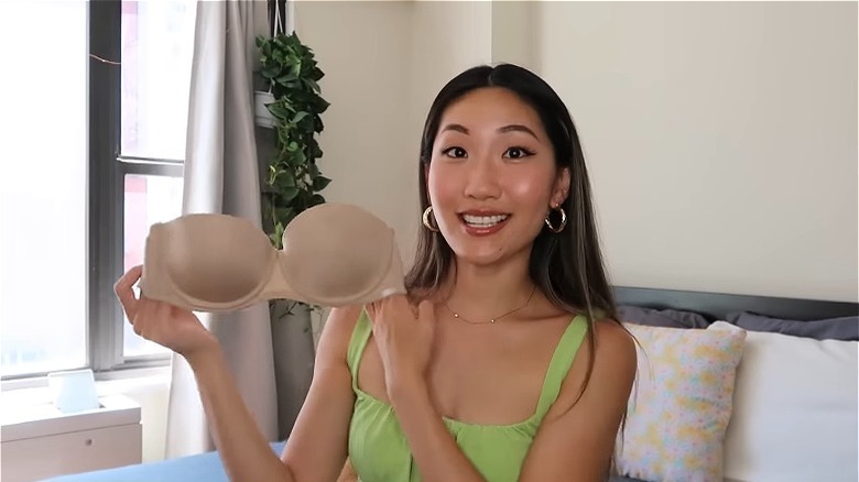 Woman holding up strapless bras 