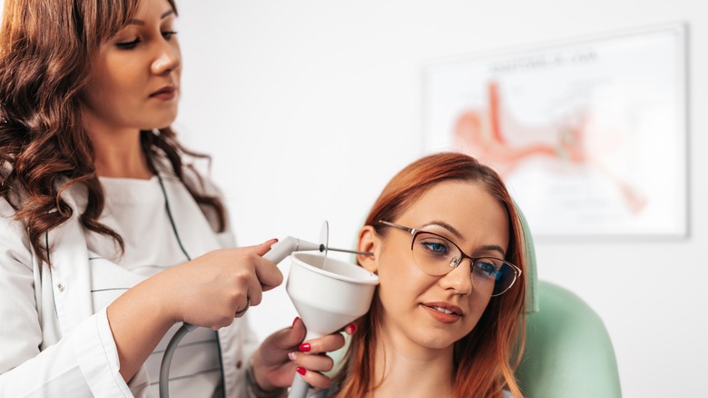 woman getting her ear irrigated at doctors office