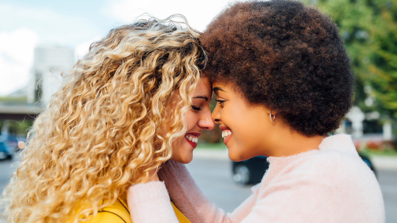 woman holding another woman's face smiling