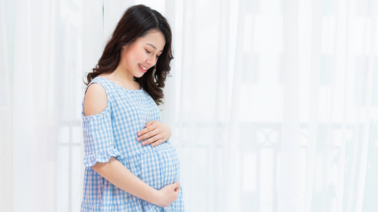 happy pregnant woman holding belly