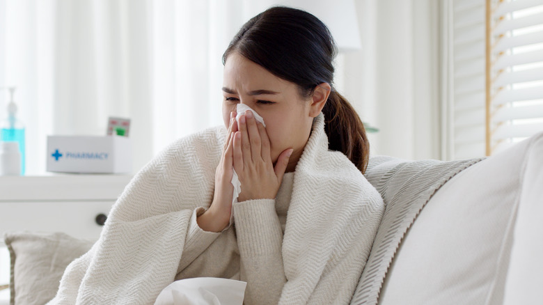 Young woman blowing her nose