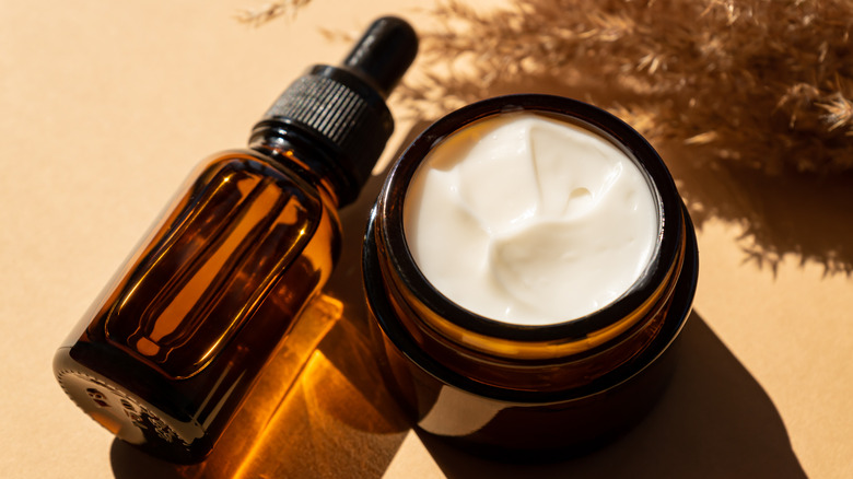 Glass containers of skincare on tan background