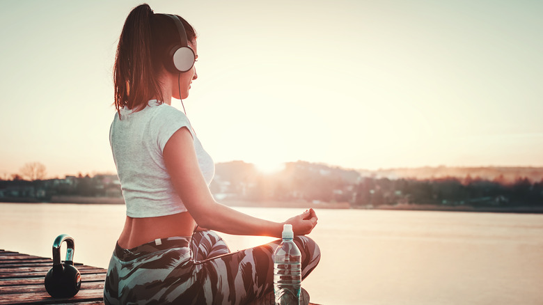 Woman sitting on boardwalk with kettlebell