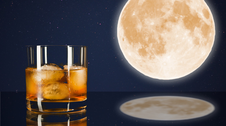 Glass of whiskey beside the full moon