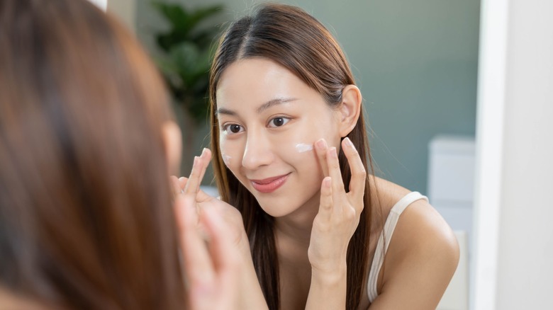 woman applying moisturizer with niacinamide