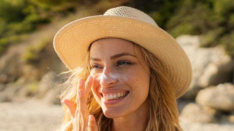 woman using sunscreen at beach