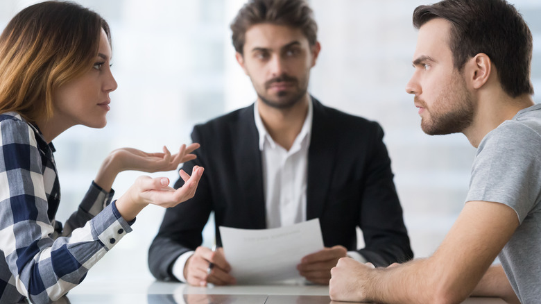 couple arguing in front of counselor or lawyer