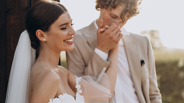 groom kisses bride's hand wedding outdoor