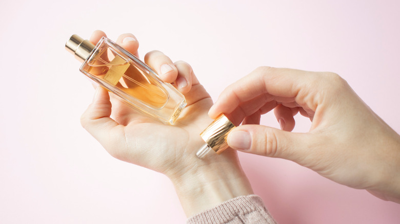 woman applying perfume to wrists